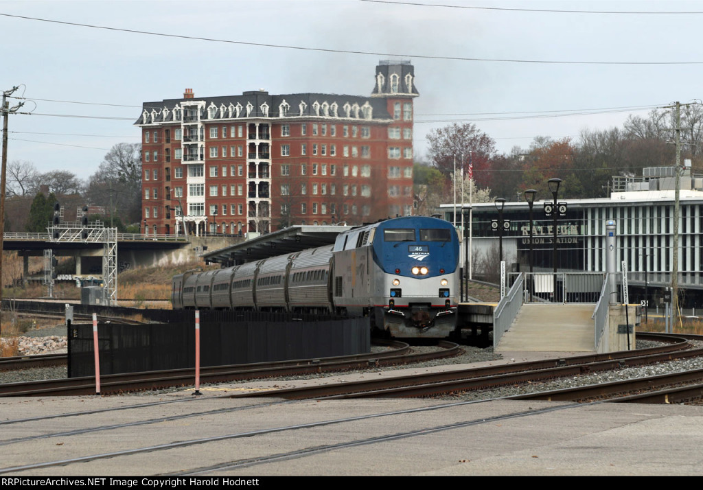 AMTK 46 leads train P080-16 away from the station